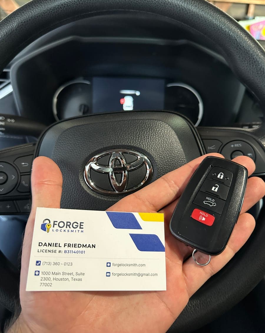 Toyota smart key programmed by Forge Locksmith, with business card at the wheel
