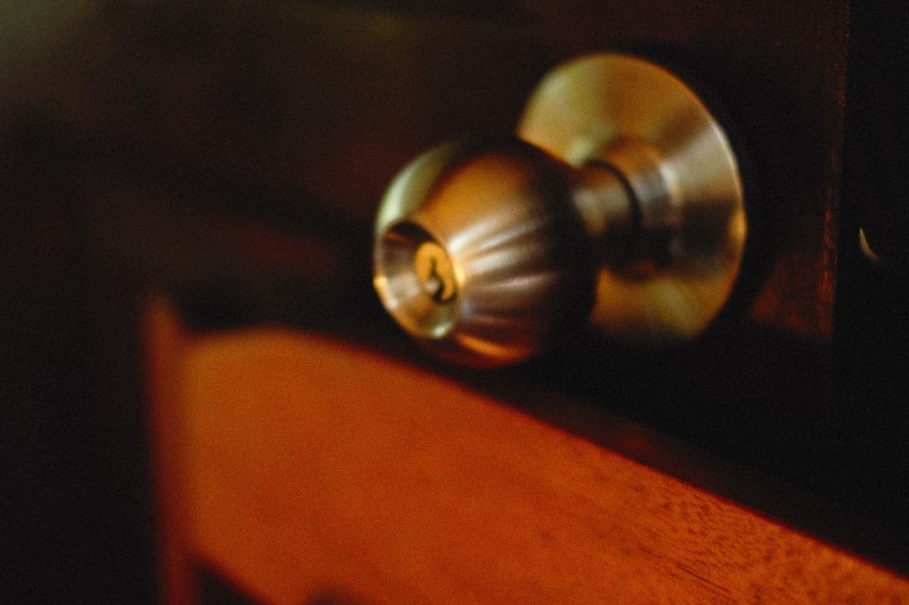Brass deadbolt and knob on a wooden door, close up